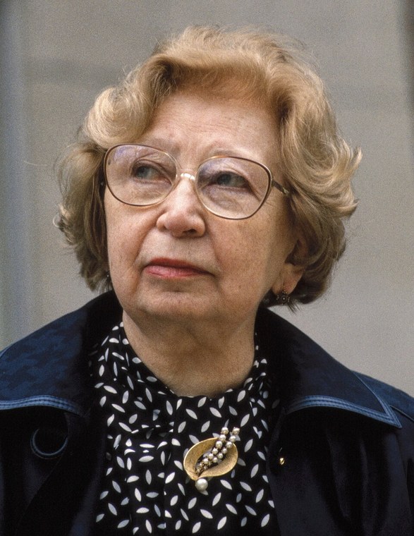 Miep Gies photographed in 1987, an older woman in glasses and a dark jacket looking past the camera