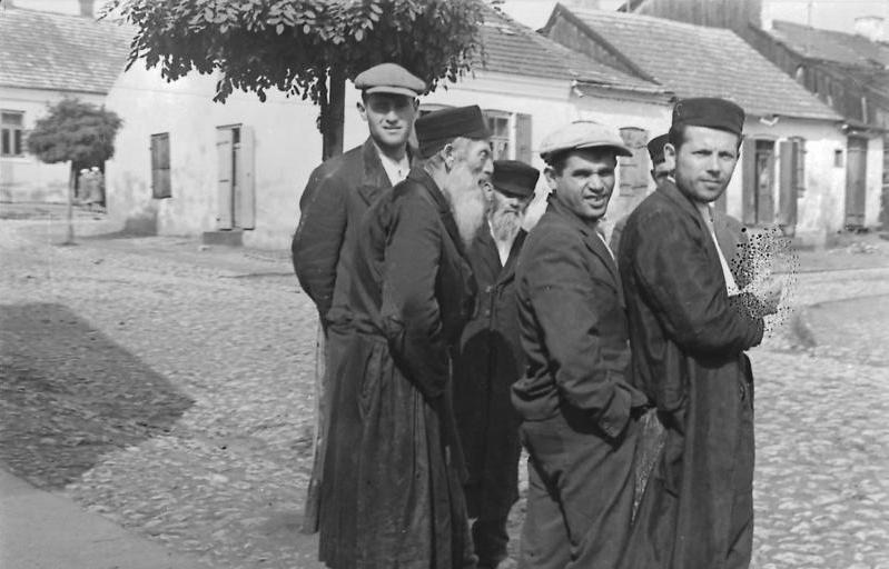 Jewish men and women photographed in the street during the German occupation of Poland.