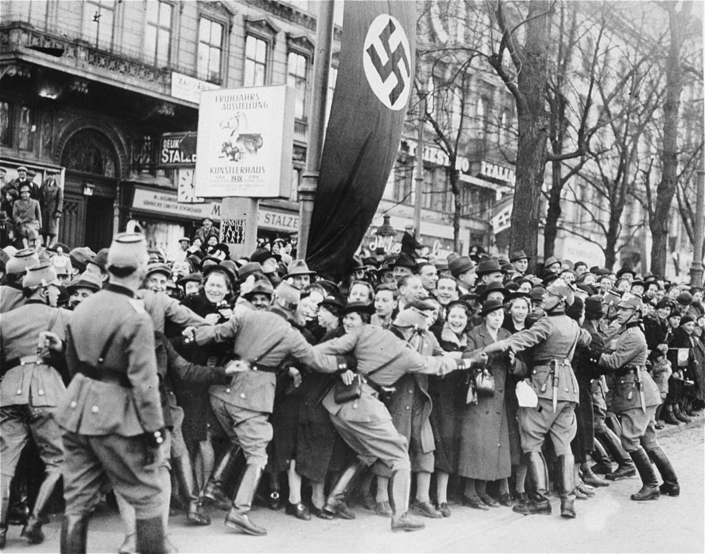 A dense crowd in a Vienna street with raised arms greeting Hitler in March 1938.