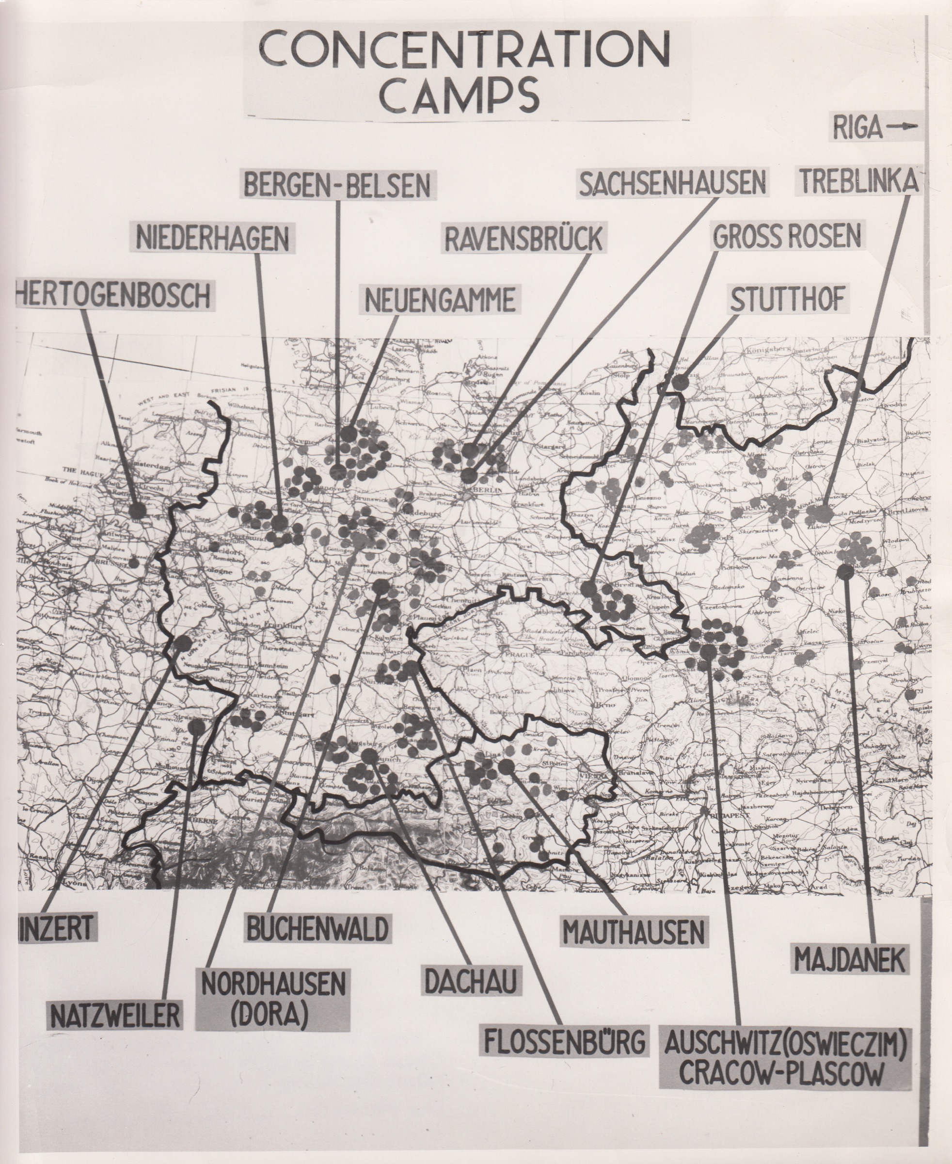 A courtroom exhibit board headed CONCENTRATION CAMPS. A base map of central Europe is overprinted with dots, scattered through Germany and Austria and clustered thickly in occupied Poland. Pasted label strips around all four edges run leader lines down to individual sites, among them Bergen-Belsen, Buchenwald, Dachau, Mauthausen, Auschwitz, Majdanek and Treblinka.