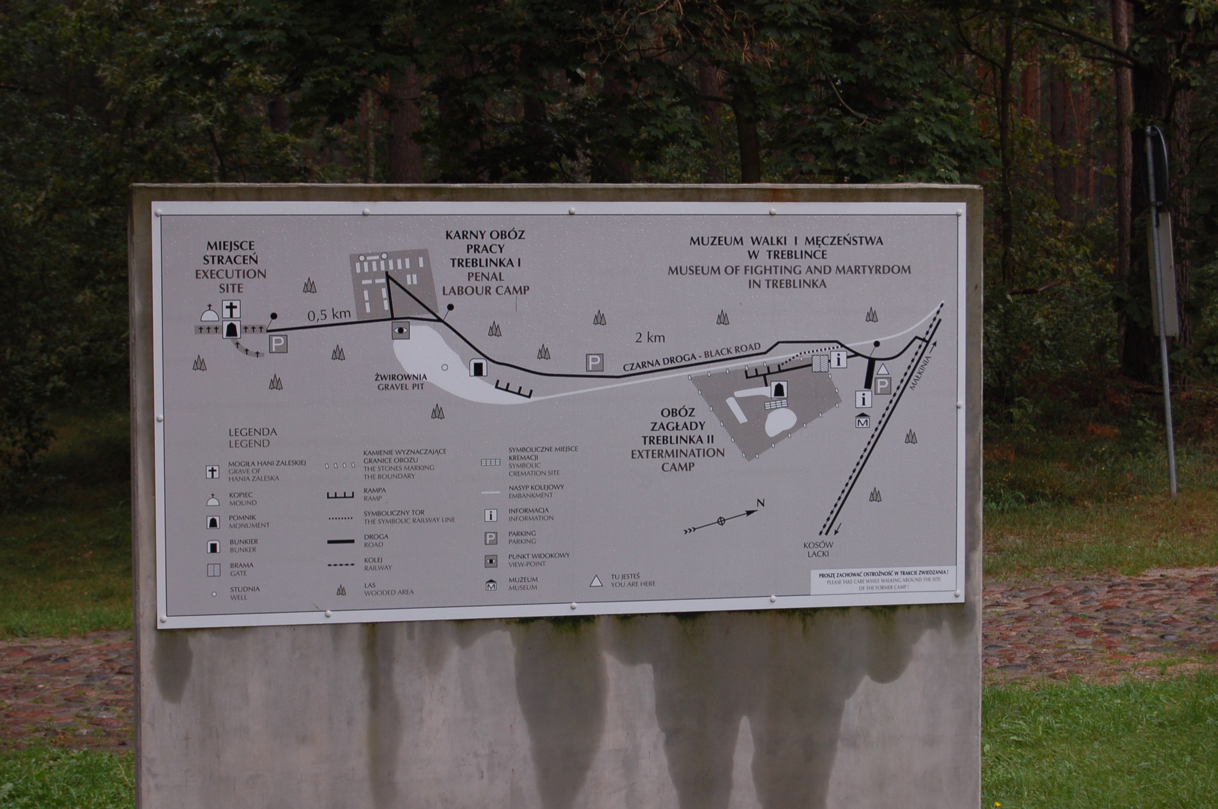 An outdoor panel showing two camp plans side by side, each with buildings, fences and a rail spur.