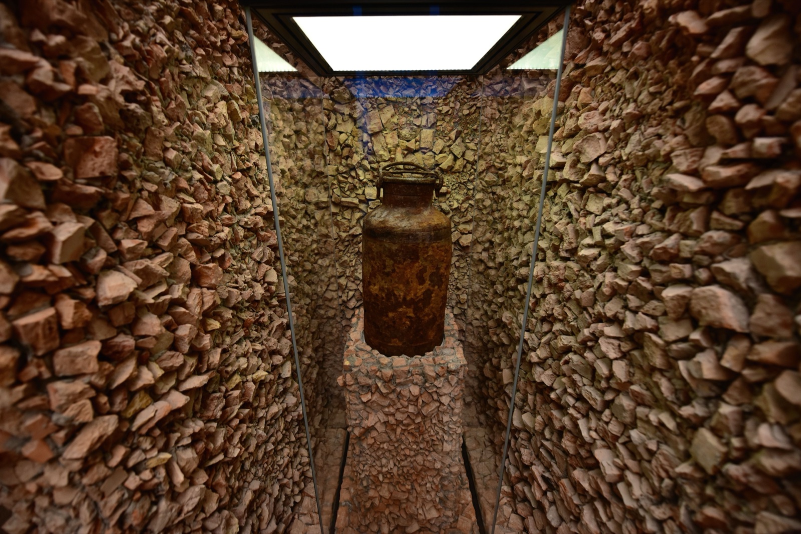 A museum gallery hung with large wall text, lit display cases holding documents standing along the floor.