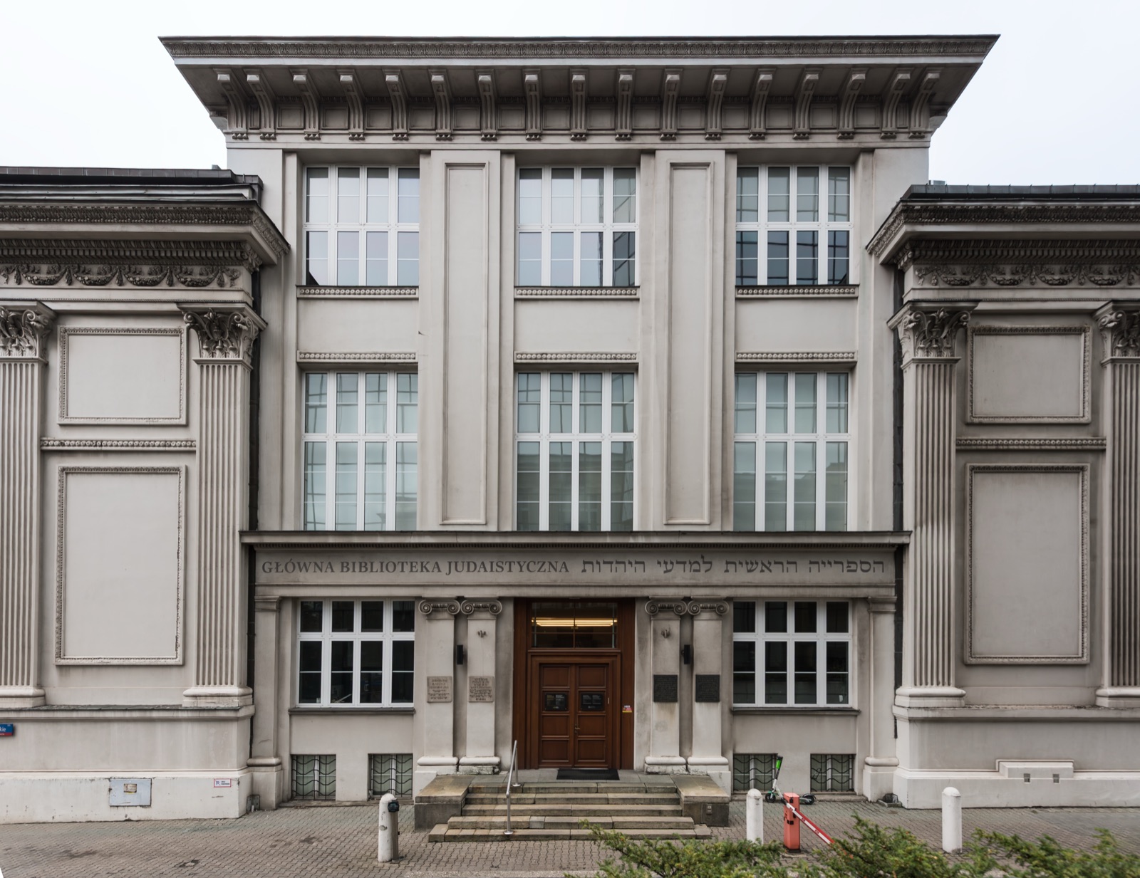 A pale rectangular building of the 1930s seen from the street corner, tall windows in regular bays and a low flight of steps at the entrance.