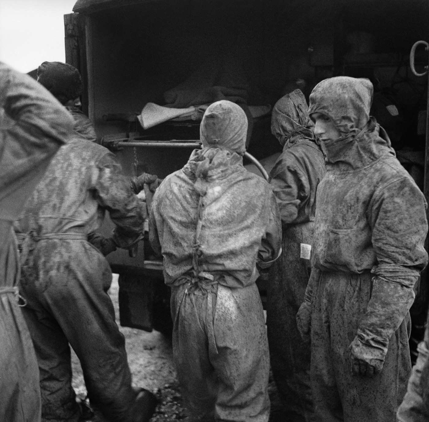 British army medical personnel in protective clothing lifting a patient into an ambulance at Bergen-Belsen.