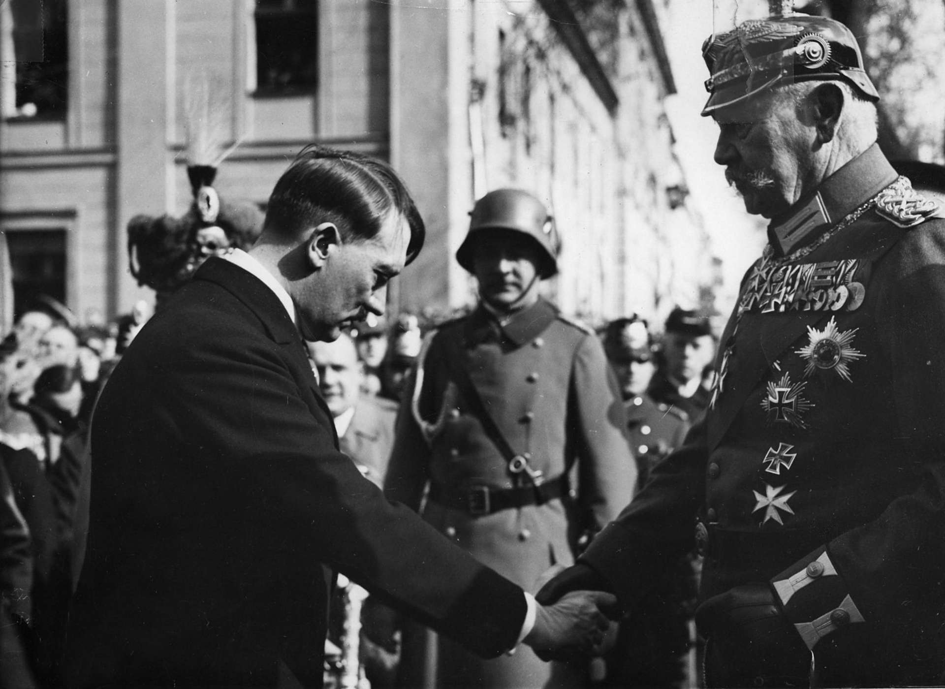 Adolf Hitler bowing as he shakes hands with President Hindenburg at the Potsdam ceremony in March 1933.