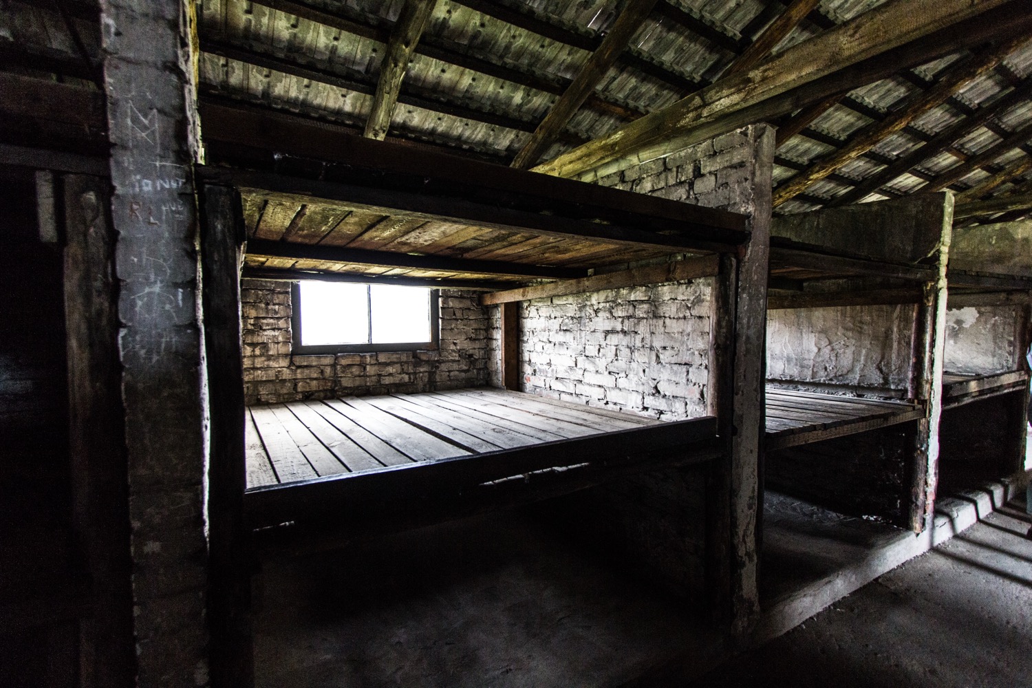 Tiered wooden bunks inside a prisoner barracks at Birkenau