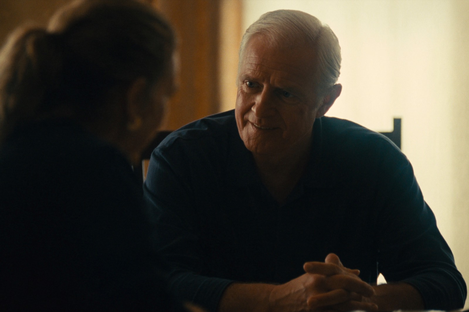 An advocate listening closely to someone across a table