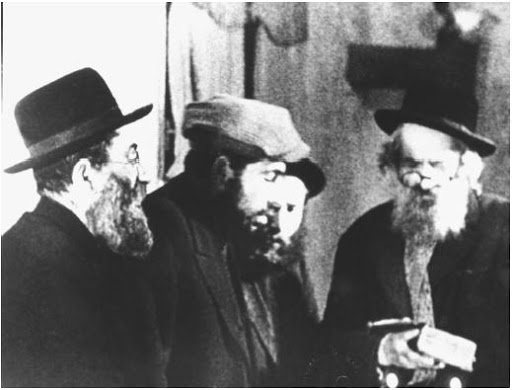 Grainy black and white frame of bearded men in hats, filmed on a street