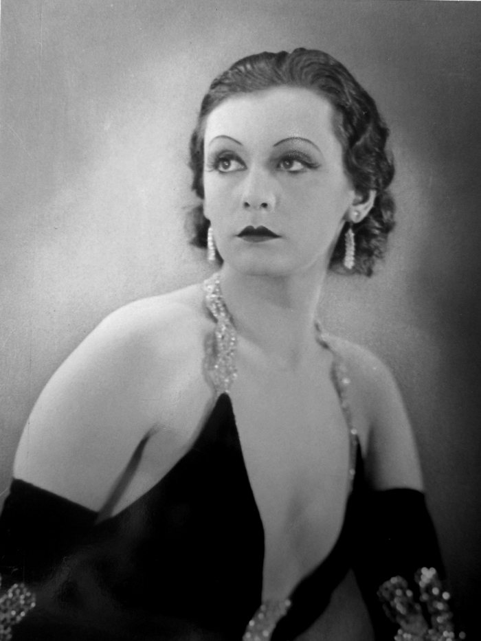 Black and white studio portrait of a woman in an evening gown