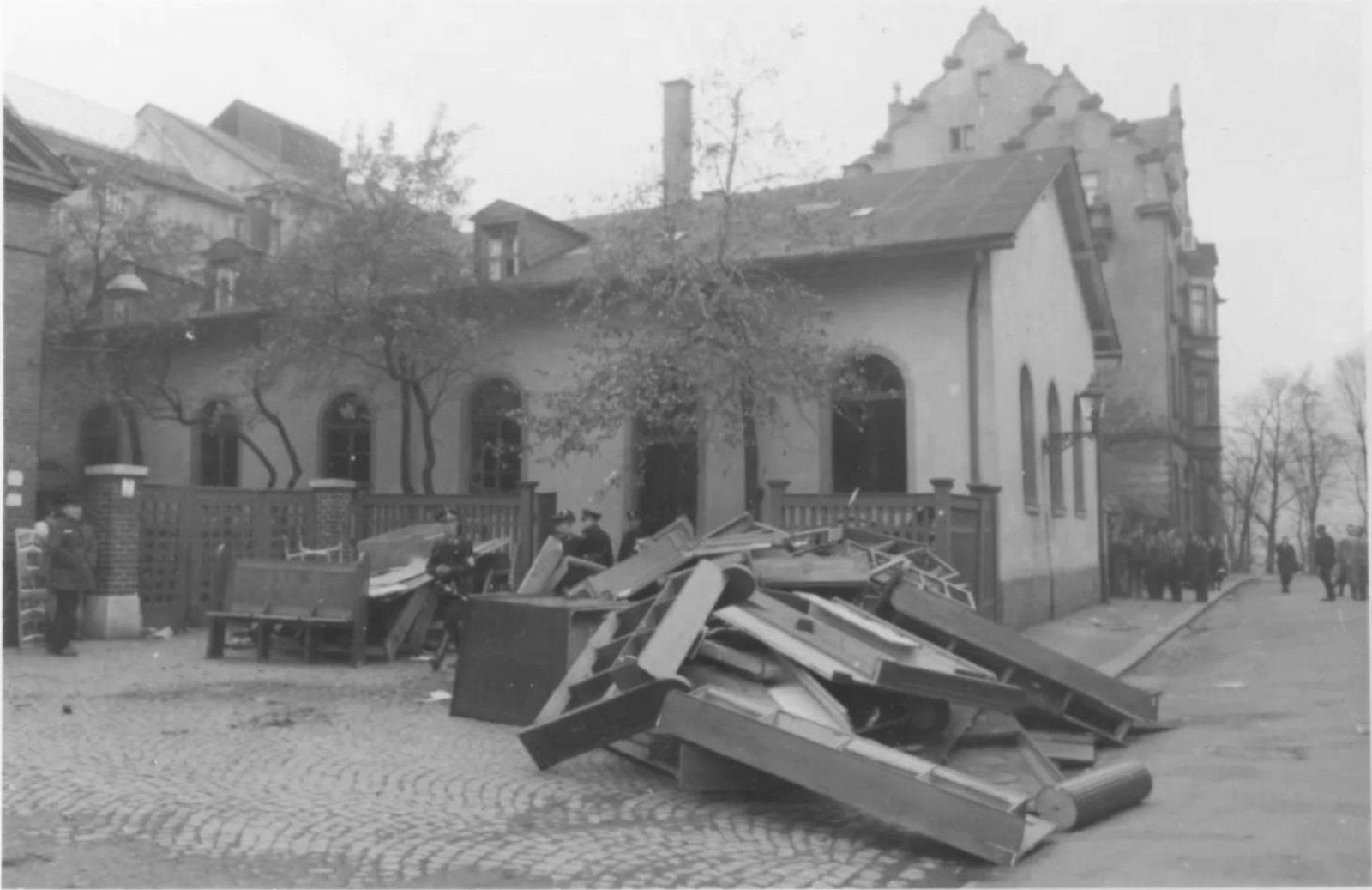 A street in a small German town photographed during the pogrom, with wreckage in the roadway and buildings along both sides.