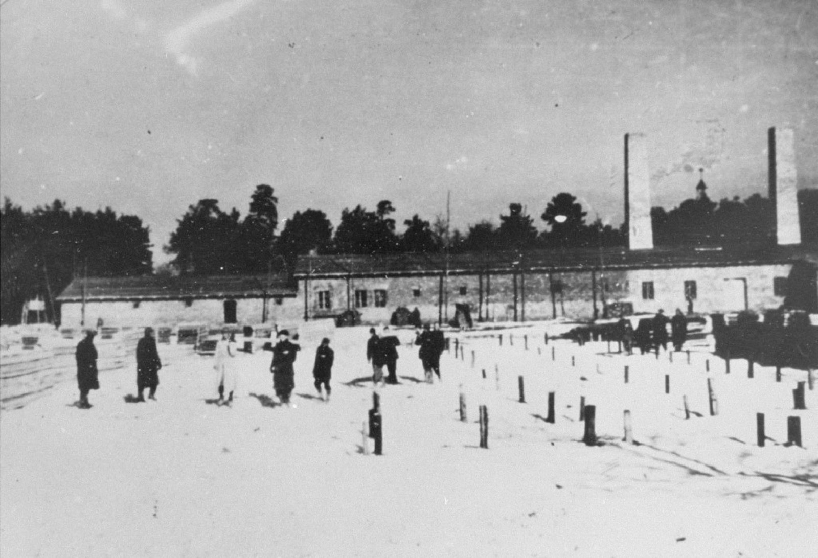 Period photograph of Crematorium IV under construction at Birkenau, 1942. Brick walls partially built, scaffolding visible.