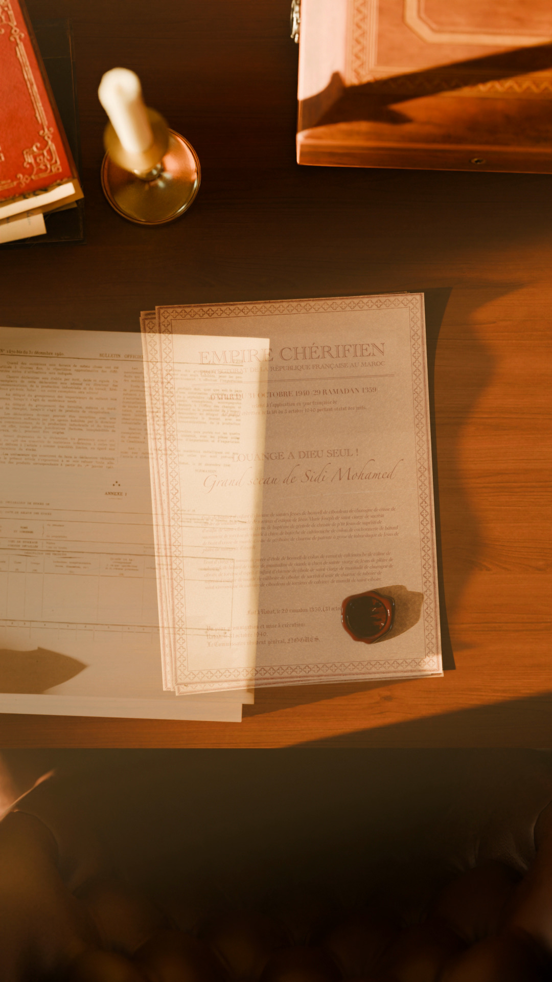 An anonymous Moroccan official's hand placing documents on top of the signed Vichy decree, burying it beneath a stack of papers.