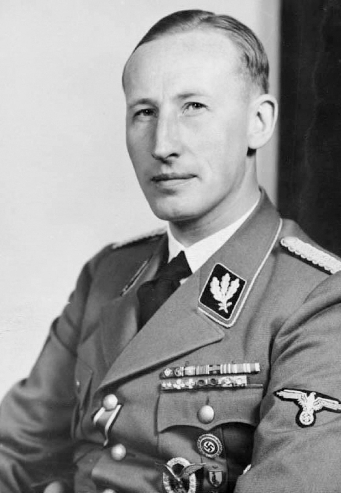 Formal portrait of a uniformed SS officer in a peaked cap, photographed in three-quarter profile.