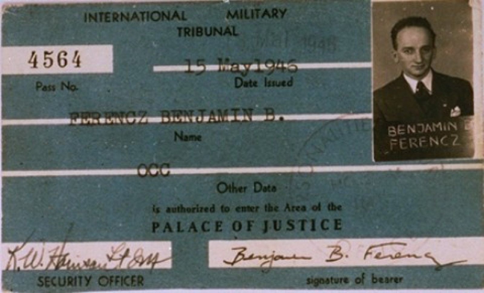 A small printed identity card carrying a typed name and a black-and-white photograph of a young man.